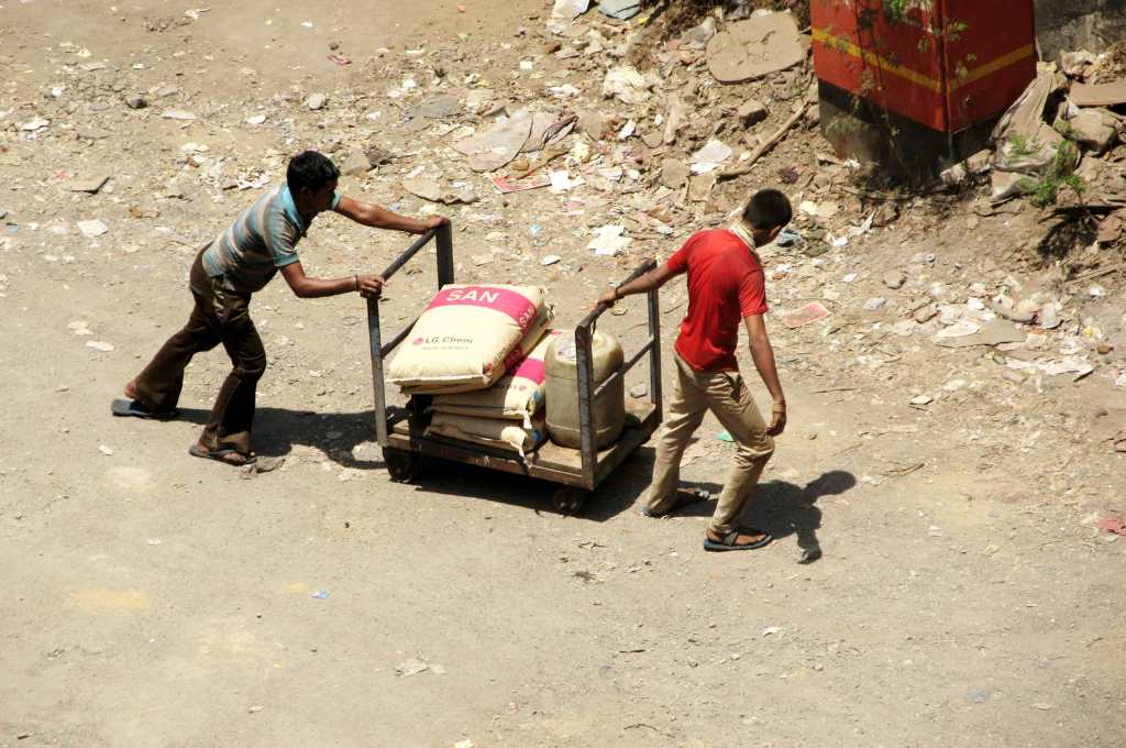 two male labourers pushing a cart- bonded labour