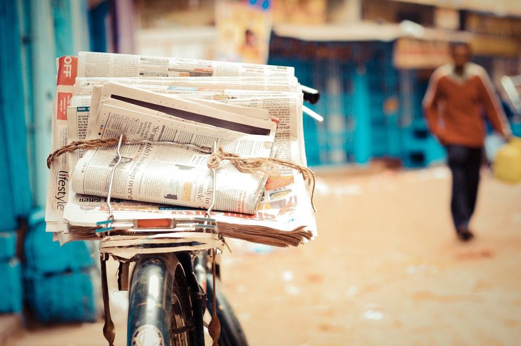 a tied-up bundle of newspapers on a bicycle carrier--nonprofit media