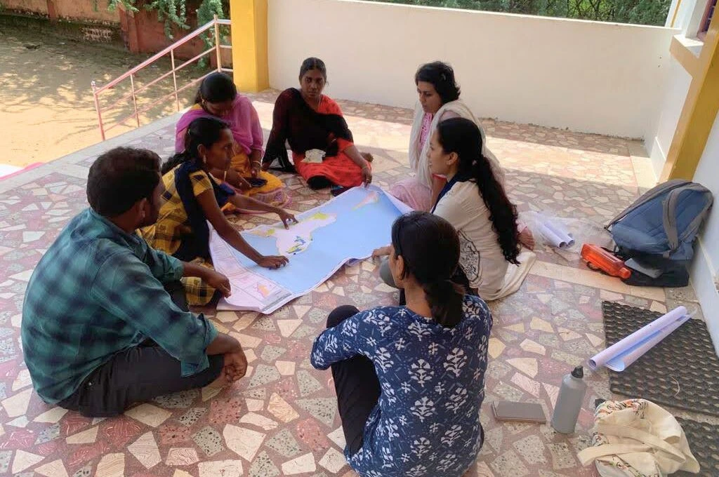 A group of people sitting together with a map_coastal mapping