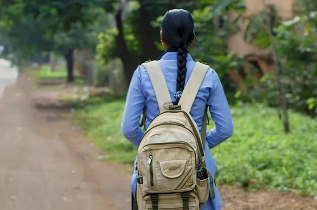 a girl wearing a school uniform and a bakcpack walking to school--MSW