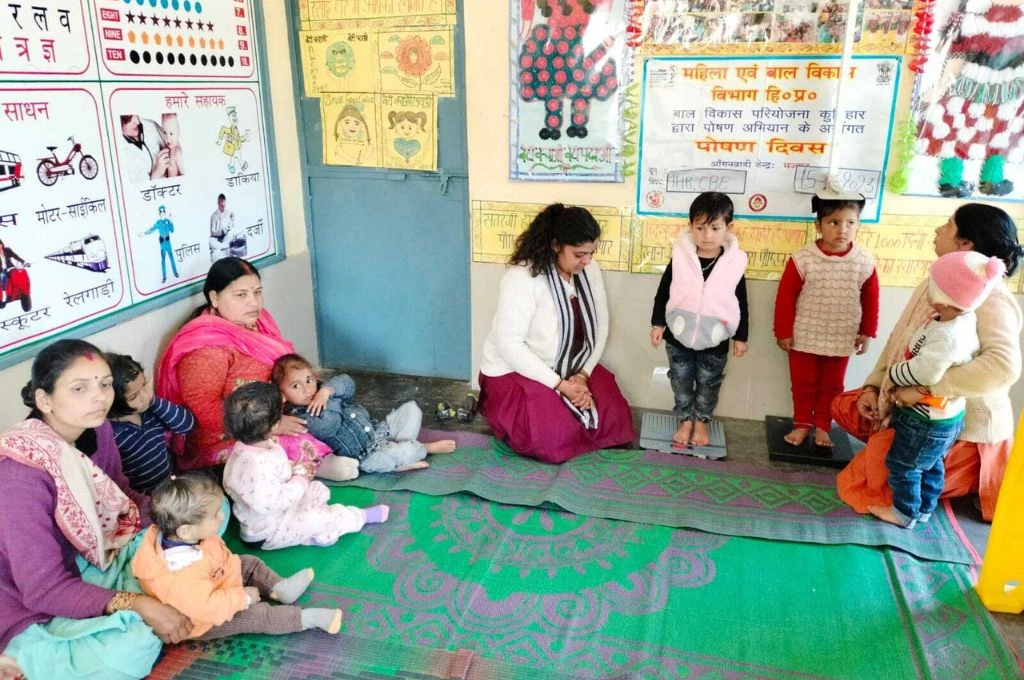 a group of children and anganwadi workers in an anganwadi