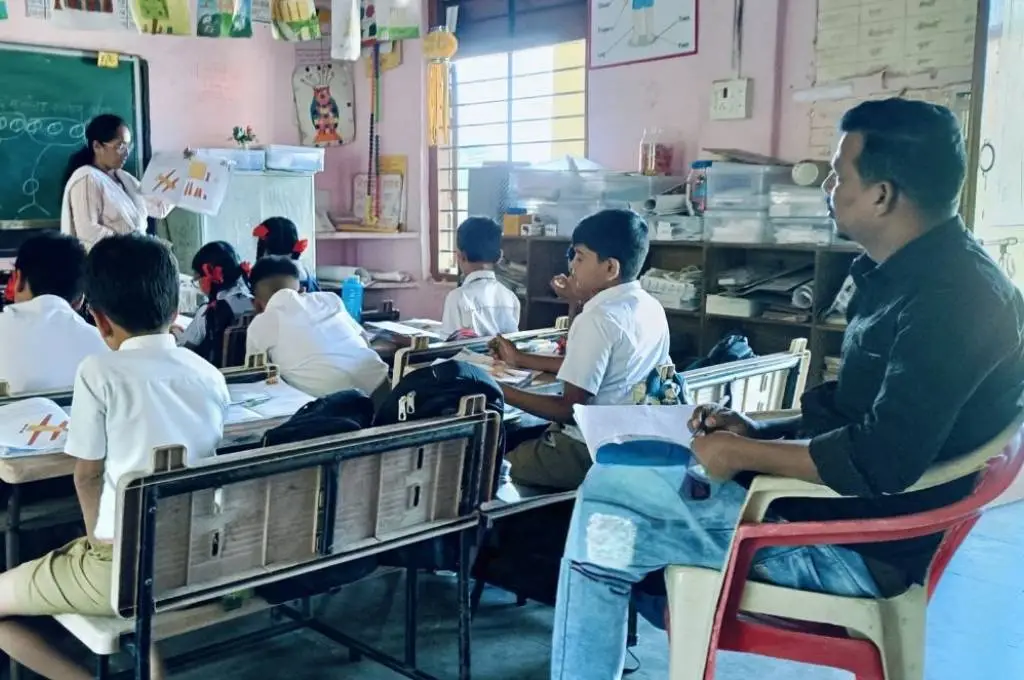 a teacher coach observing a class in session--government school teachers