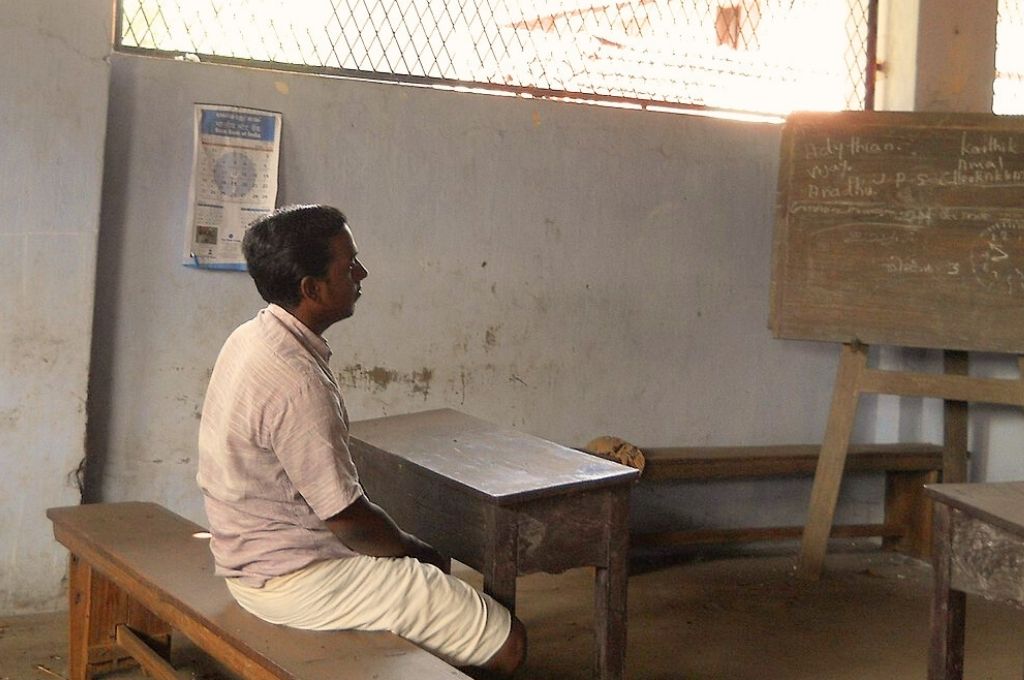 man staring at run down black board-teacher training