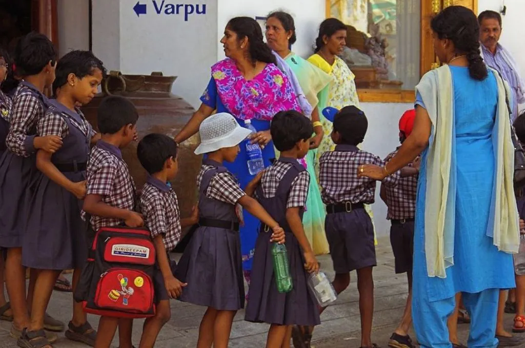 A group of schoolchildren walk in a line accompanied by their teachers. - Inclusive education