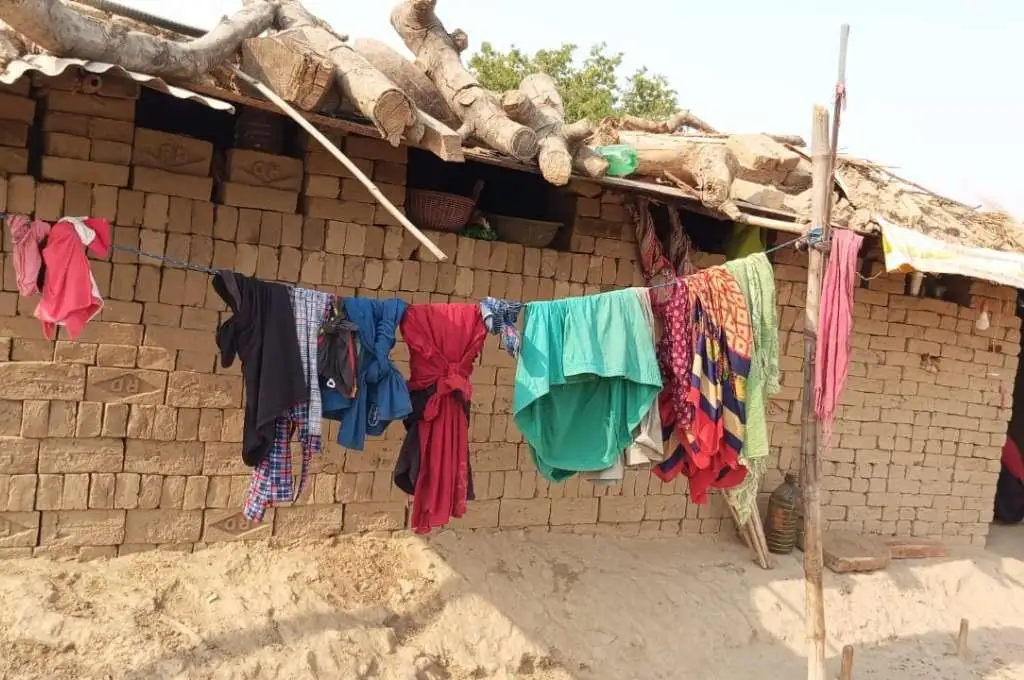 clothes hanging outside a brick hut--menstrual health