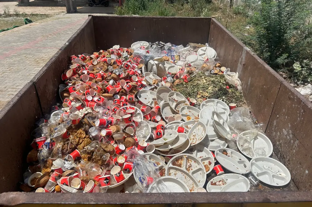 Dumpster filled with disposable plates and cups_waste management