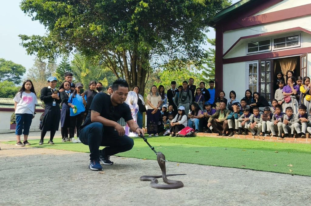 A Save the Riparian member with a snake in front of a crowd of children-environmental campaign