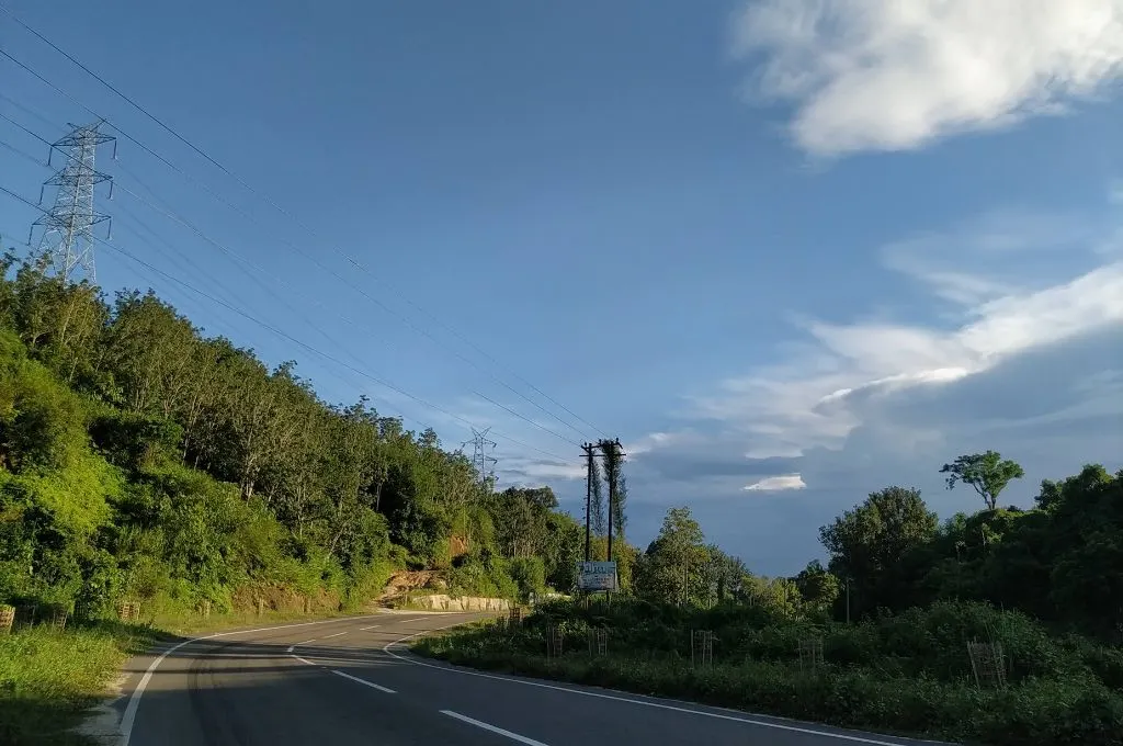 National Highway 8 near Laikhua, Tripura, with clear blue skies and forested hills to one side--bamboo-based livelihoods