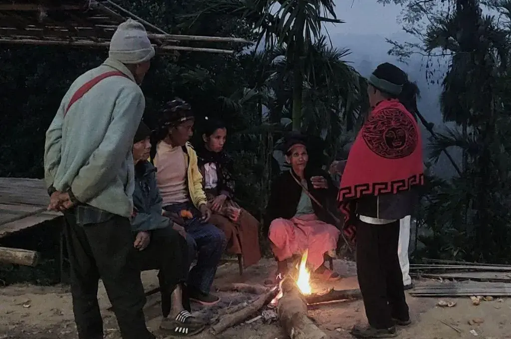 a group of people standing and sitting around a fire--bamboo-based livelihoods