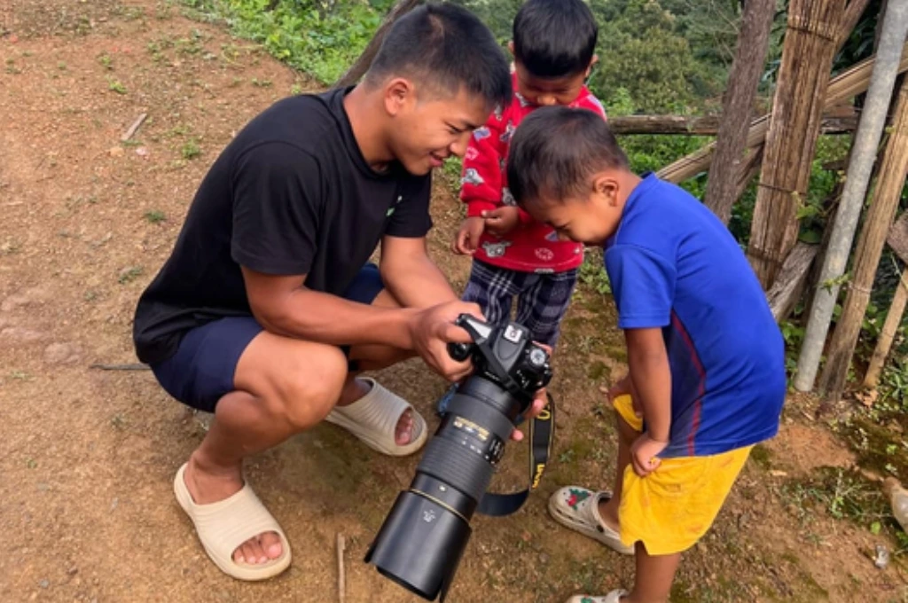 a man shows his camera to two children--conservation