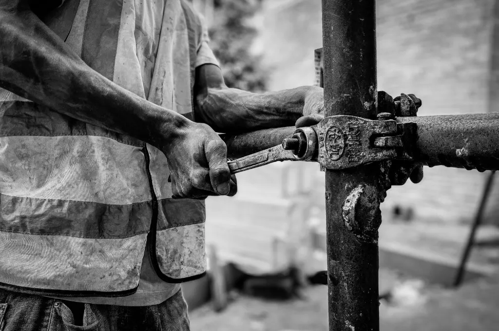 a worker holding a wrench at a construction site--MGNREGA