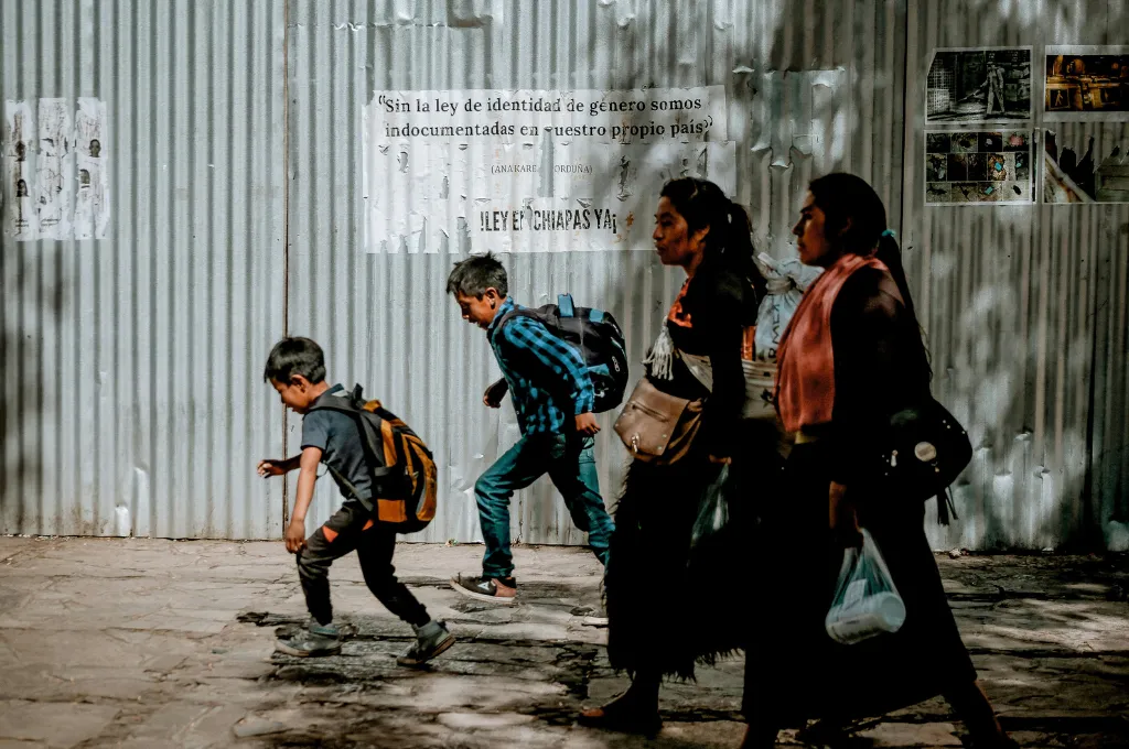 two women walking alongside two boys--public transport