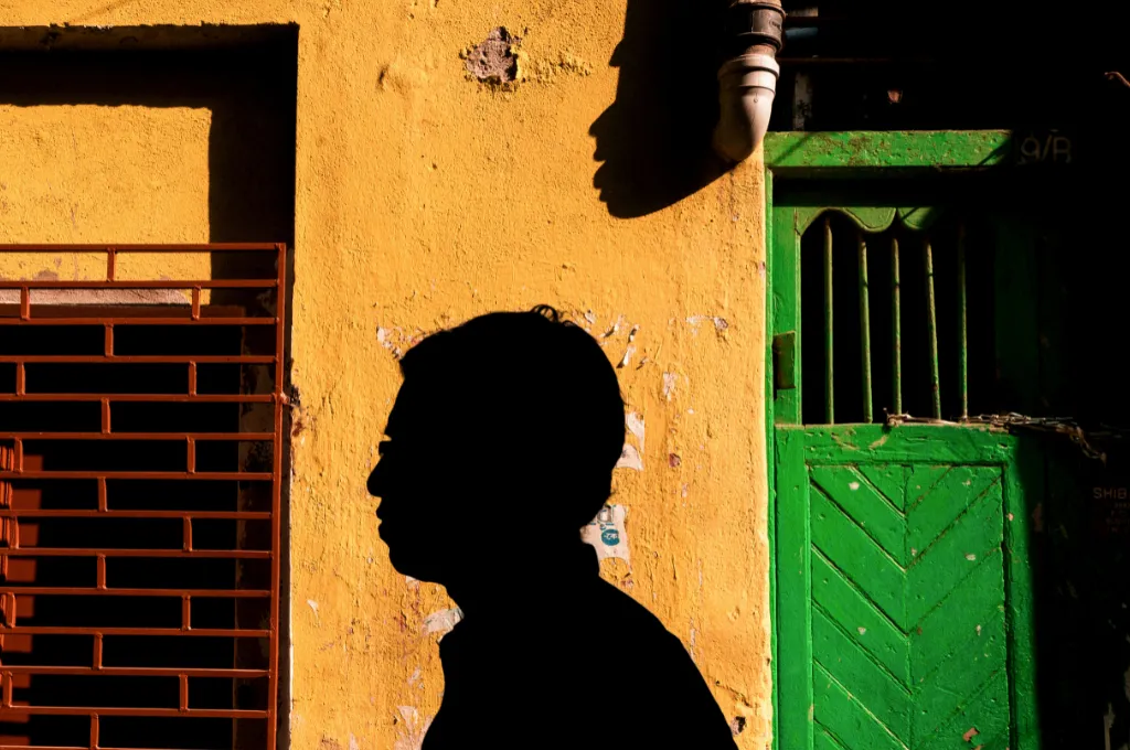 a man's shadow on a yellow wall--social sector conferences