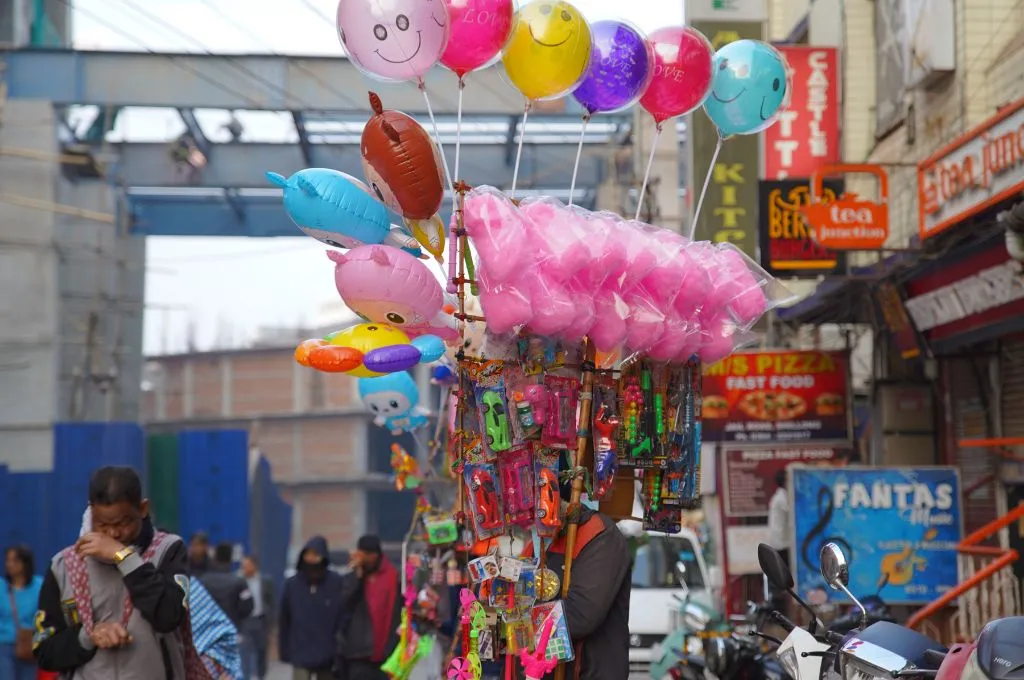 a lively market with street vendors selling cotton candy and balloons--street vendors