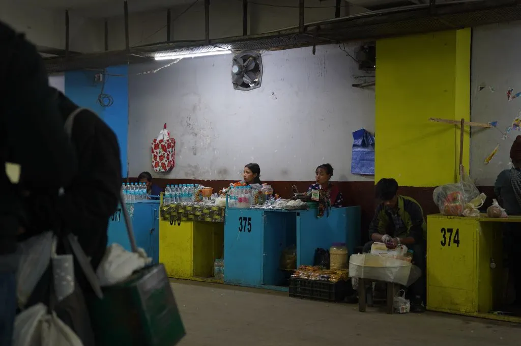 a row of street vendors selling packaged goods and plastic water bottles--street vendors