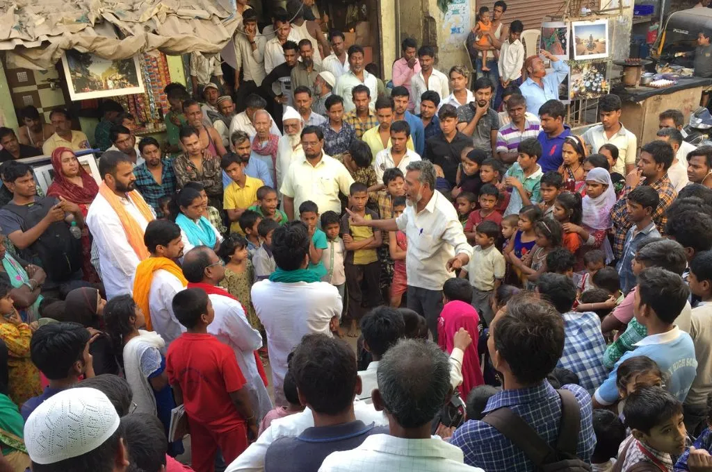 a large crowd being addressed by a man standing in the centre--right to water