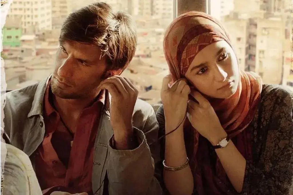 bollywood actors ranveer singh and alia bhatt sharing a pair of headphones in a still from a film--nonprofit humour