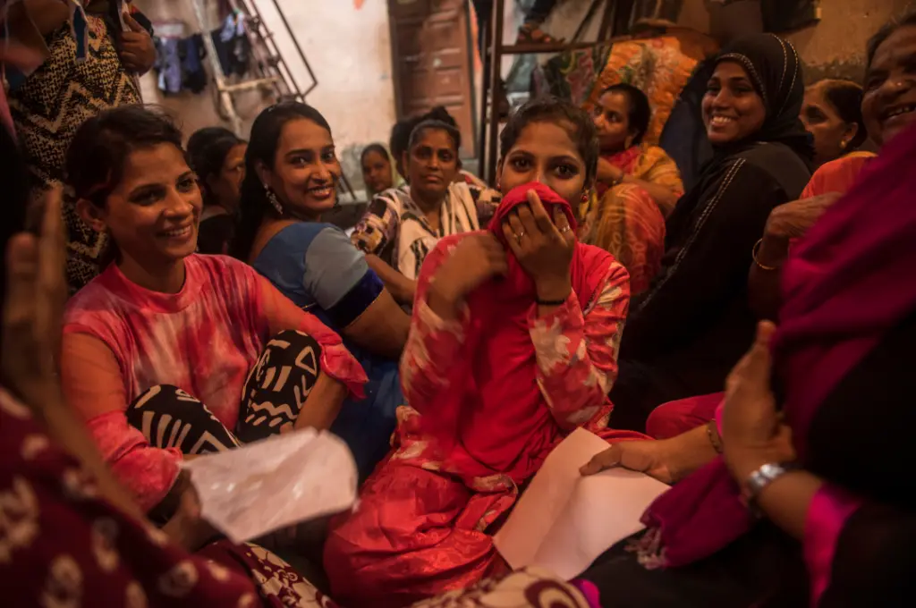 a group of women huddled close together and smiling--gender-based violence