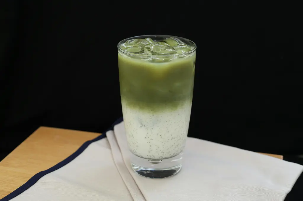 a close up shot of a matcha latte glass placed on napkins on a table--nonprofit humour
