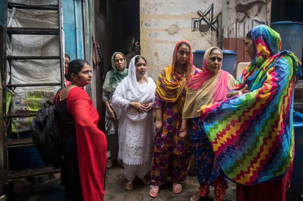 a group of women standing on the street, with all the other women looking at the speaker--gender-based violence