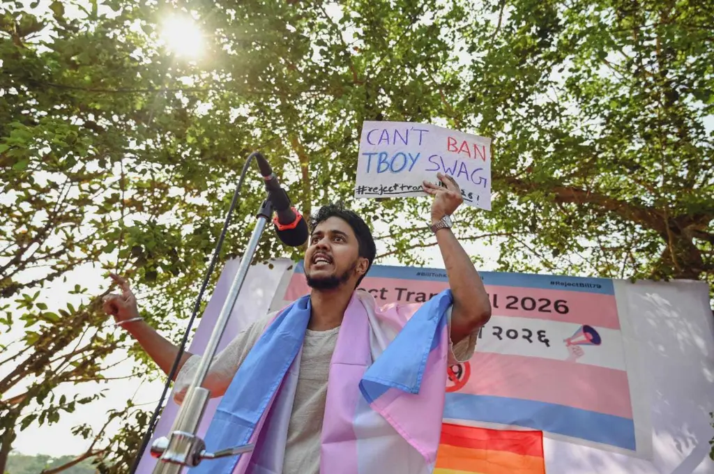 a person holds up a sign that says 'Can't ban Tboy swag' at a protest against the Transgender Persons (Protection of Rights) Amendment Bill 2026--Trans Amendment Bill