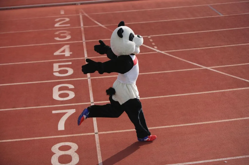 a person in a panda suit crosses a finish line with their arms opened wide and angled towards the back--nonprofit humour