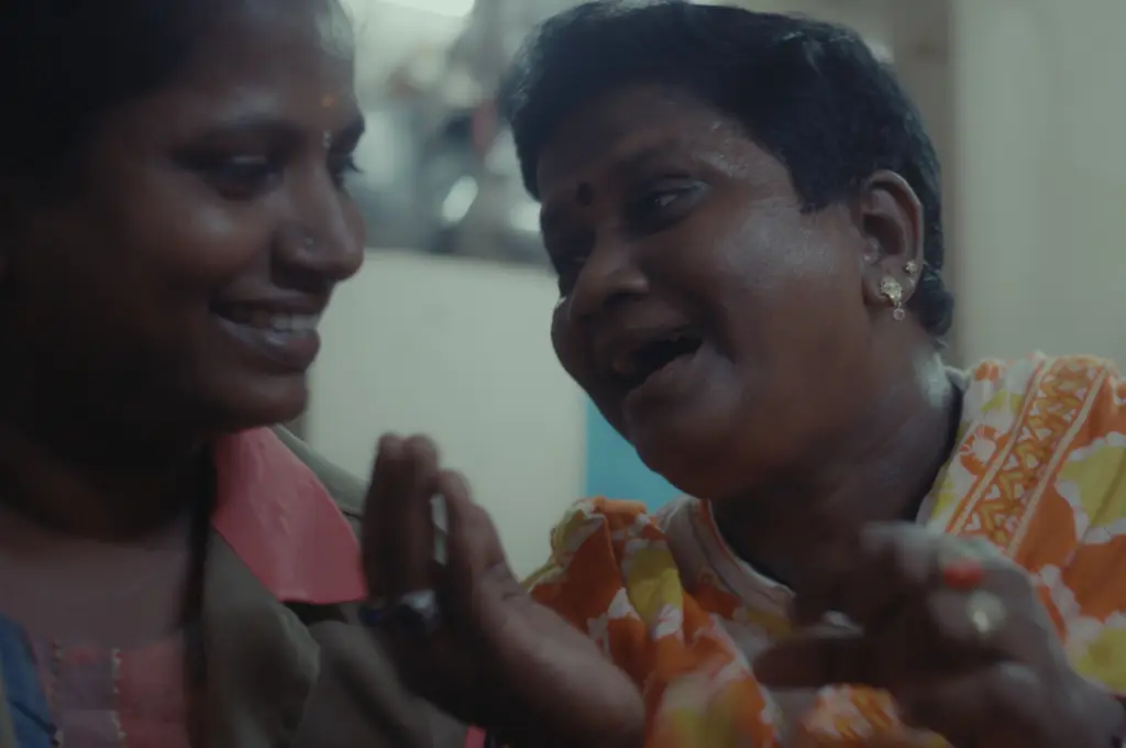a close up shot of two women smiling and talking to each other--women auto drivers