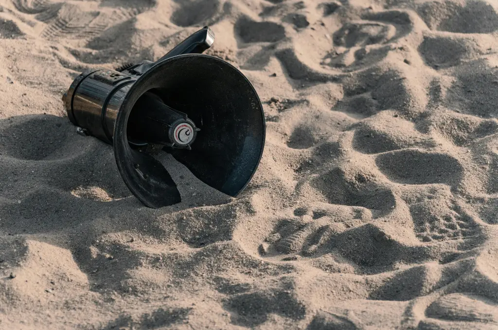 a black microphone on a sandy beach--civil society