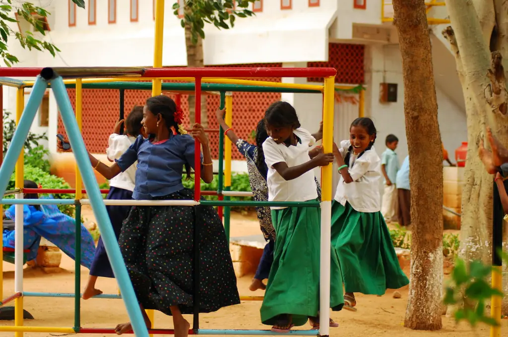 young girls playing among swings in a playground--right to play