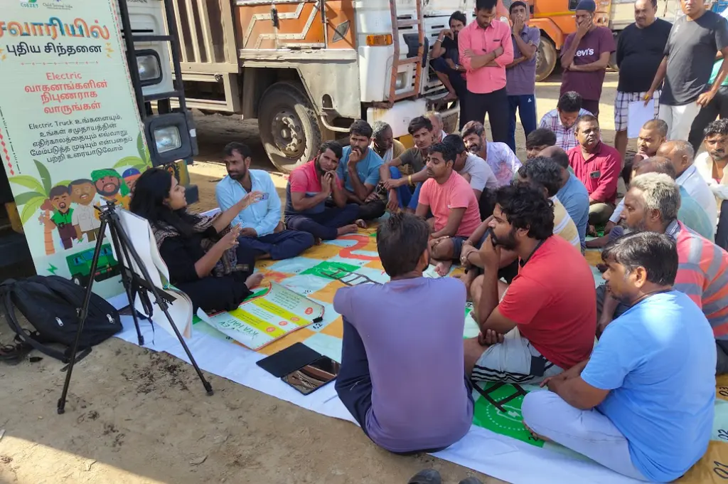 a group of people attending a session while sitting on a life-sized snakes-and-ladders board--unorganised sector India