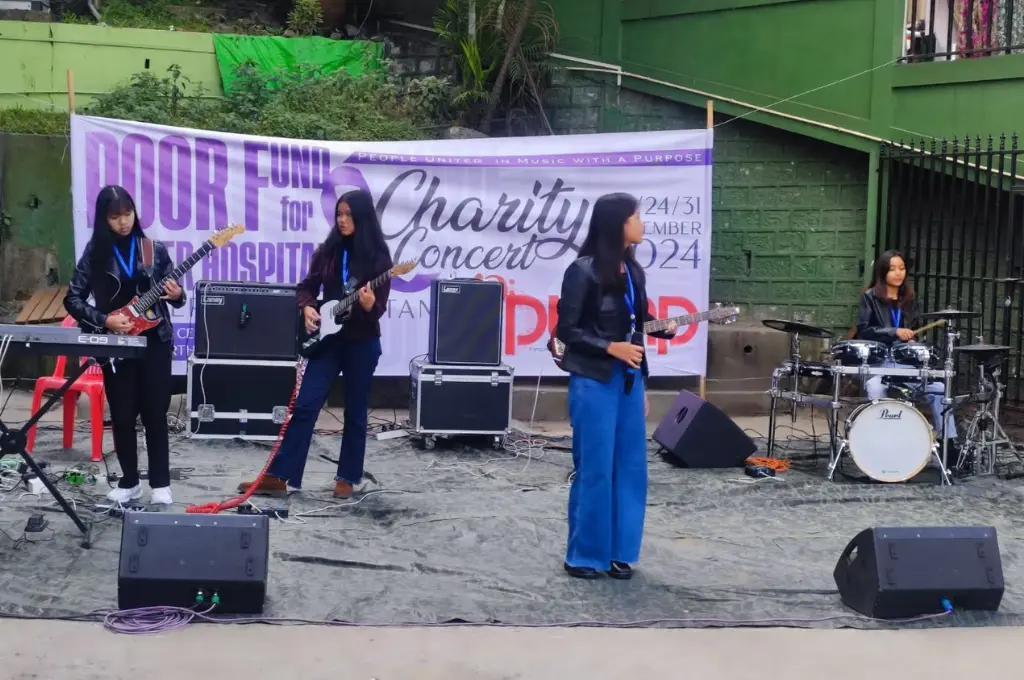 a band playing on a stage with a banner saying 