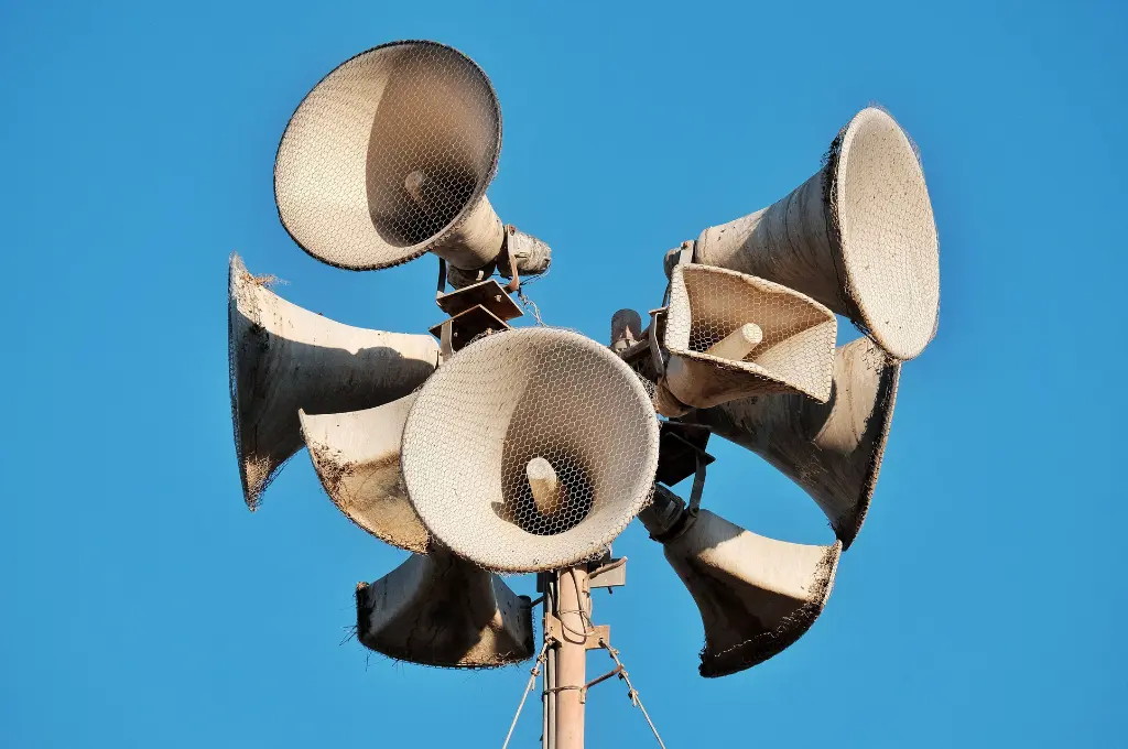 Close-up of megaphones on a pole against a clear blue sky--communications