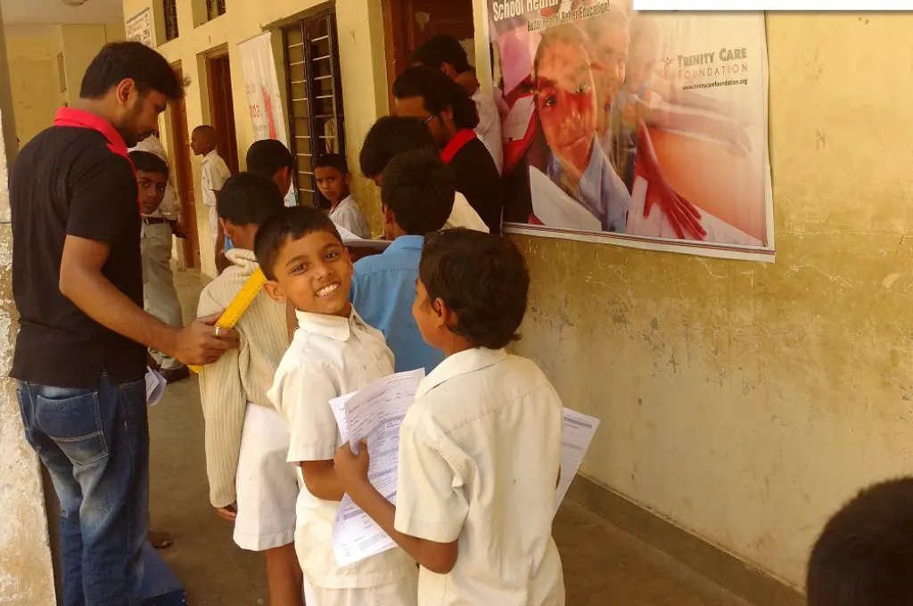school children standing in a queue, with one boy looking at the camera and smiling--socio-emotional learning