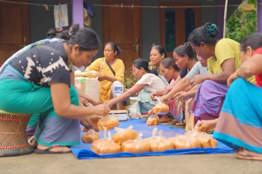 a group of women in Meghalaya sitting on the floor packing chili powder--Meghalaya livelihoods