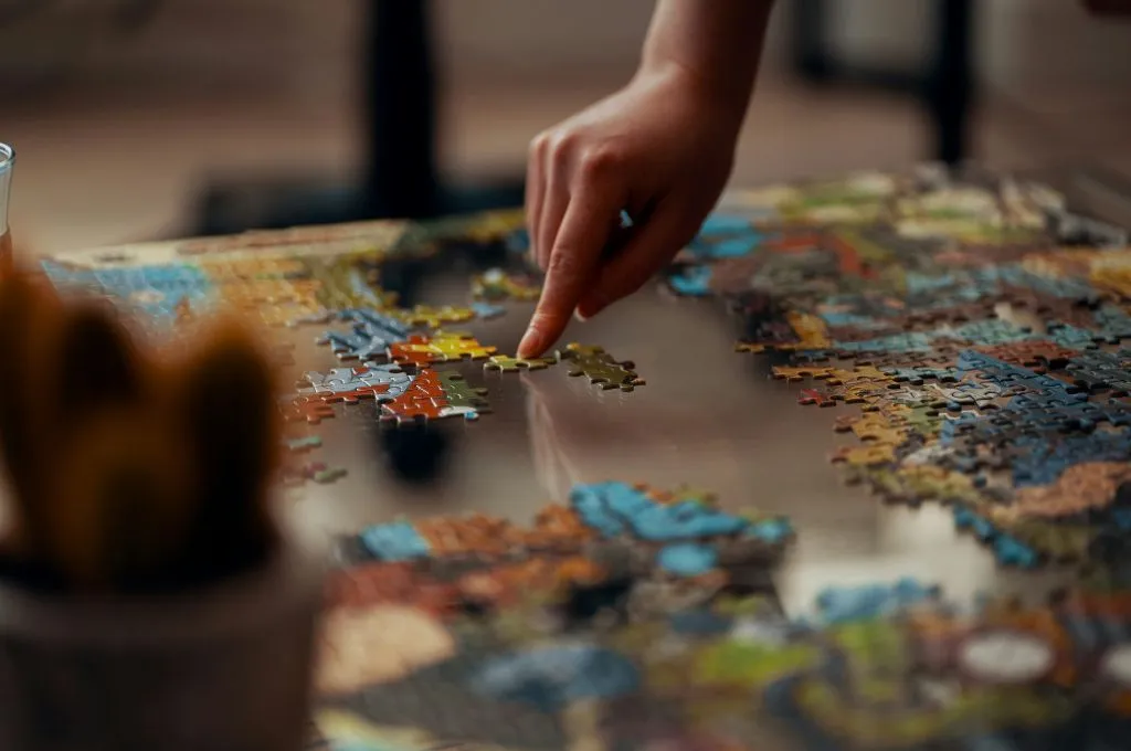 close up shot of a hand with the fore finger touching a jigsaw puzzle piece that is surrounded by several other pieces--nonprofit boards