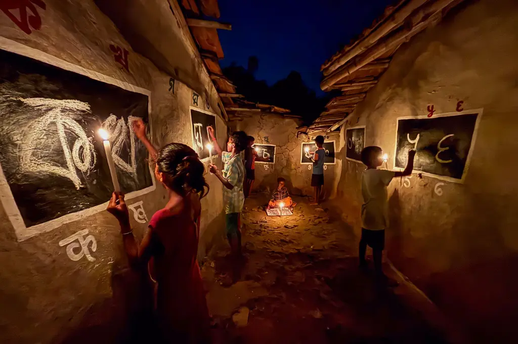 children writing the bengali alphabet on blackboards painted over mud walls by candlelight--scholarships for students
