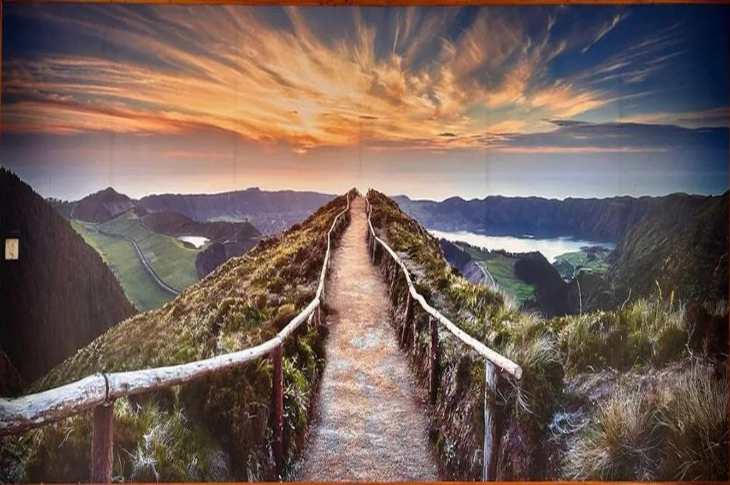 a mural of a bridge slowly ascending; in the distance are mountains, a lake, and a bright orange sky--hospice facilities