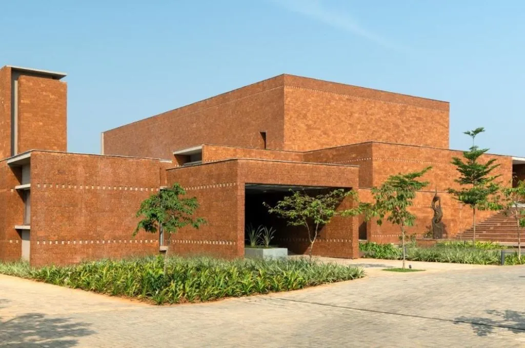a red building with a laterite exterior and a few trees in the front--hospice facilities