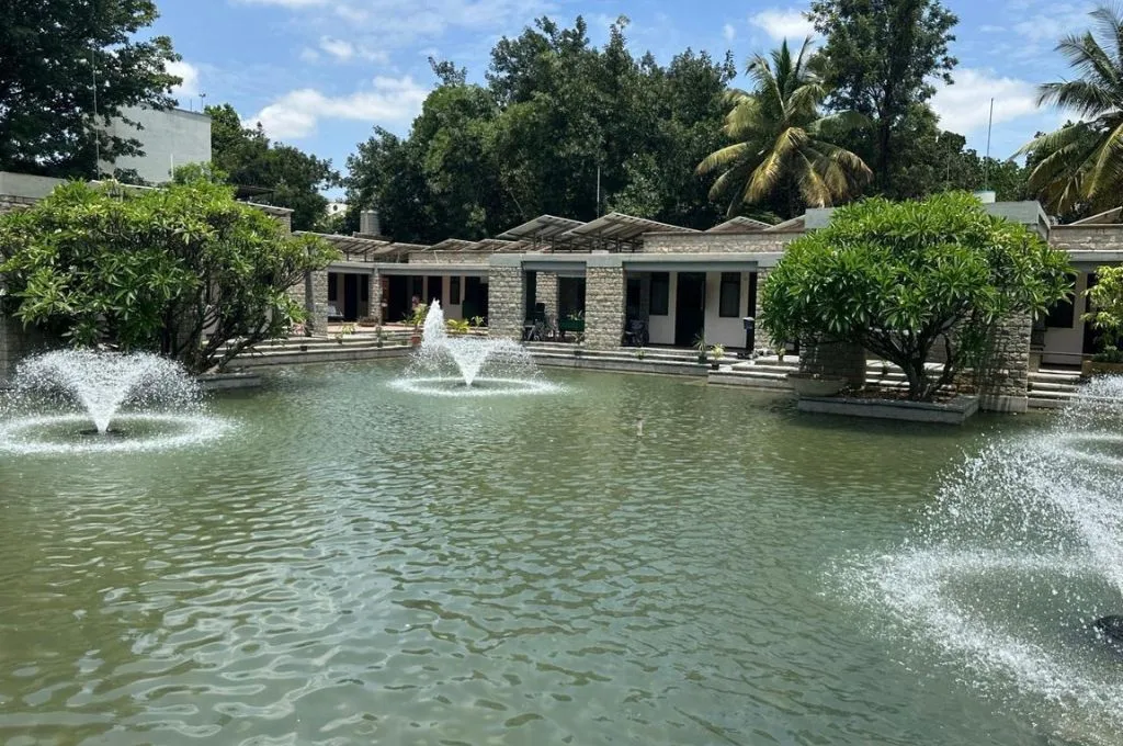 a pond with fountains surrounded by grey buildings on all sides--Hospice facilities