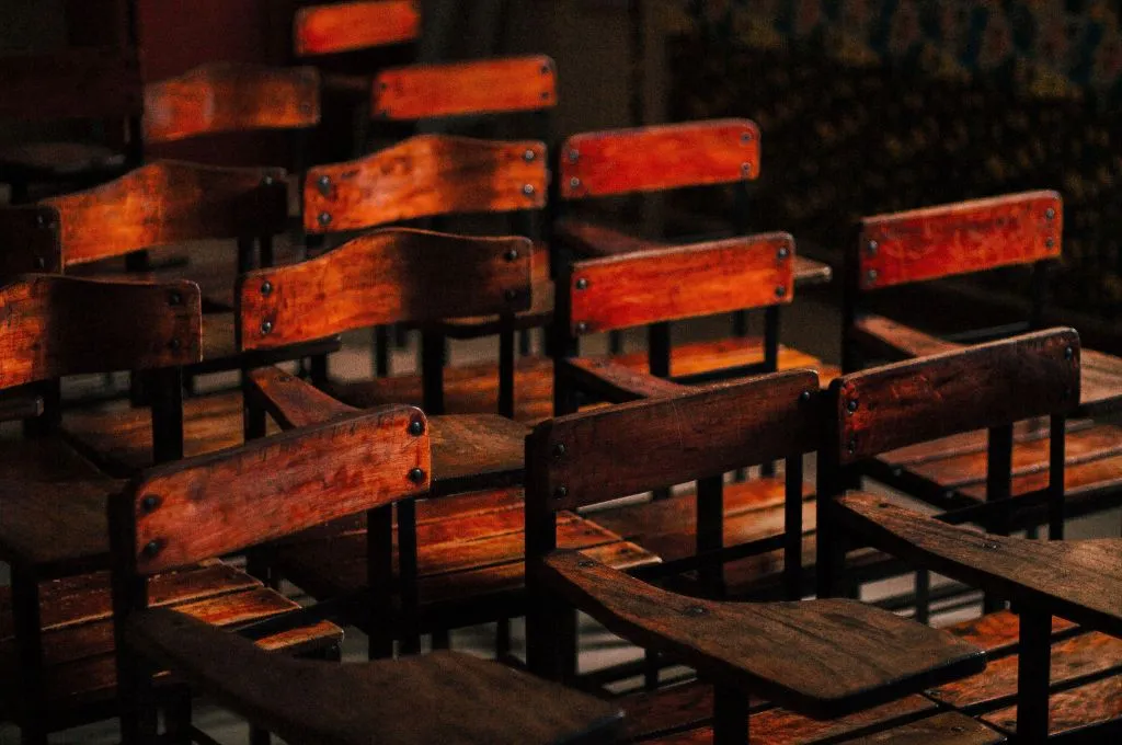 brown chairs in a dark, empty classroom--teacher education