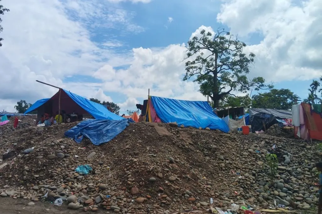 makeshift blue tarpaulin tents set up on higher ground after a flood--Assam flood