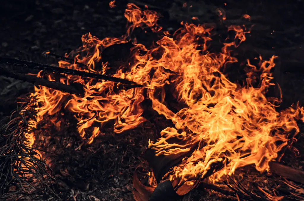 A close-up of a vibrant campfire burning brightly in a dark forest--CSR