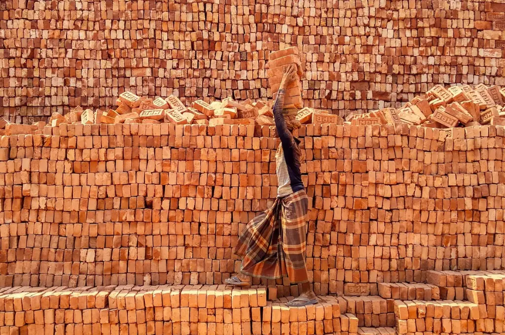 A worker balancing bricks on his head at a brick kiln in Bangladesh--social sector