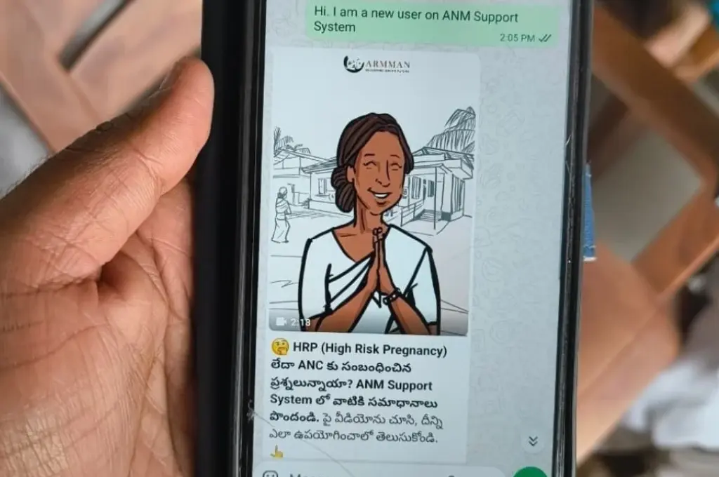close-up shot of a person's hands holding a smartphone, which is open to a WhatsApp conversation between an ANM and a support chatbot--AI tool